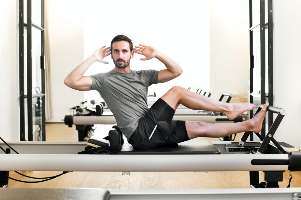 Man performing a pilates single leg stretch
